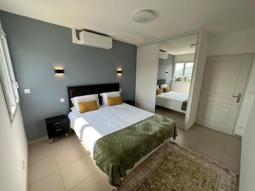 a bedroom with a large bed and a mirror at Jolie Appartement T3 Brive in Brive-la-Gaillarde