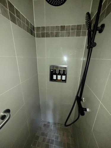 a bathroom with a shower with a black shower head at Spa Nature Estrie in Saint-Herménégilde