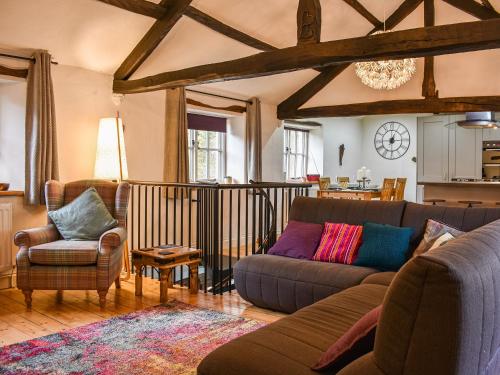 a living room with a couch and two chairs at Forge Cottage in Keswick