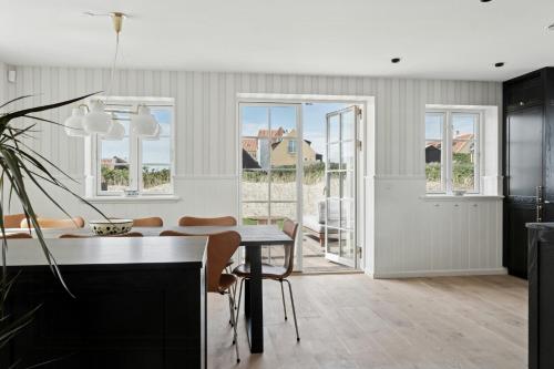 スケーエンにあるNew Holiday Home Near The Beach In Old Skagenのテーブルと椅子のあるキッチンとダイニングルーム