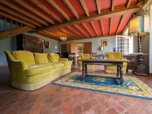 un salon avec un canapé et une table dans l'établissement Maison calme avec grand terrain, proche commodités et sites médiévaux - FR-1-582-133, à Allègre