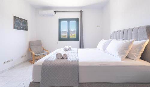a bedroom with a white bed with two towels on it at White Wave in Logaras