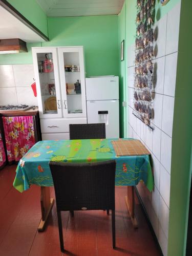 a kitchen with a table and chairs in a room at La maison Margouillat bord de mer in Paea