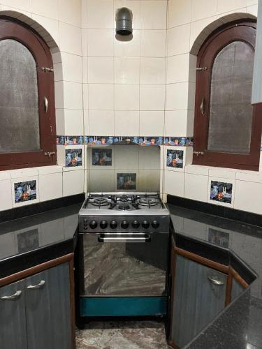 a kitchen with a stove and two windows at The Citadel in Srinagar