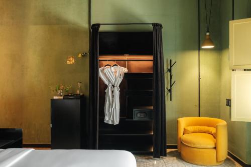 a bedroom with a bed and a yellow chair at Pug Seal Oaxaca in Oaxaca City