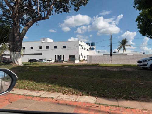 a white building with cars parked in front of it at Cubo Hotel in Rio Branco