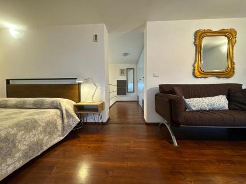 a bedroom with a bed and a couch and a mirror at Appartamento Selene in Monopoli