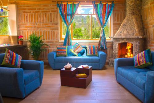 a living room with two blue couches and a fireplace at Watzara Wasi Dpt Familiar cerca de Cuicocha in Cotacachi
