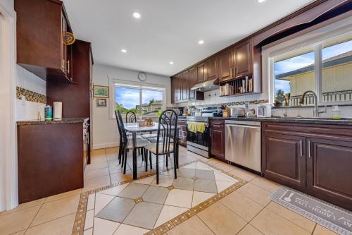 a kitchen with wooden cabinets and a table with chairs at Quite House near the Vancouver Airport in Richmond
