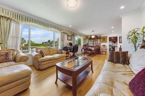 a living room with couches and a table at Quite House near the Vancouver Airport in Richmond