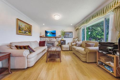 a living room with two couches and a fireplace at Quite House near the Vancouver Airport in Richmond