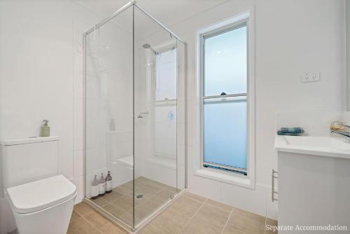 a bathroom with a shower and a toilet and a sink at Beachstay Hideaway Vincentia by Book Jervis Bay in Vincentia