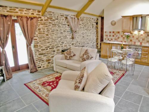 a living room with two white couches and a kitchen at Lower Shippen - 23493 in North Petherwin