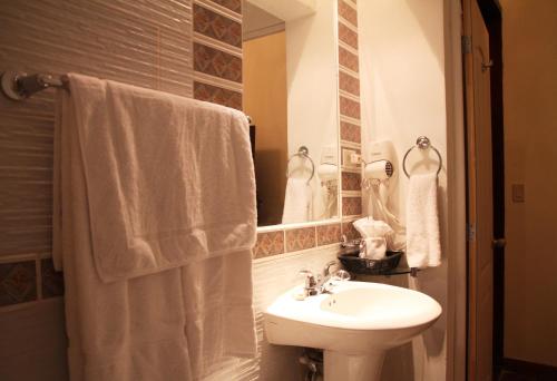 a white bathroom with a sink and a mirror at Hotel Los Altos Esteli in Estelí