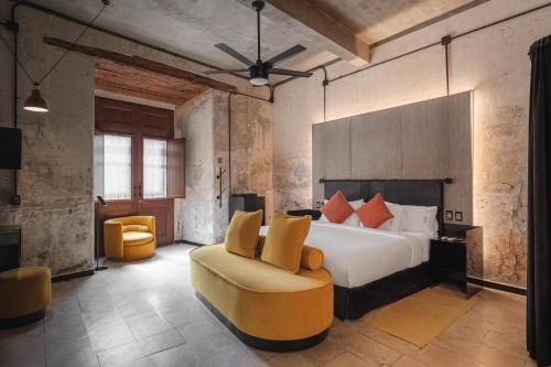 a hotel room with a bed and a chair at Pug Seal Oaxaca in Oaxaca City