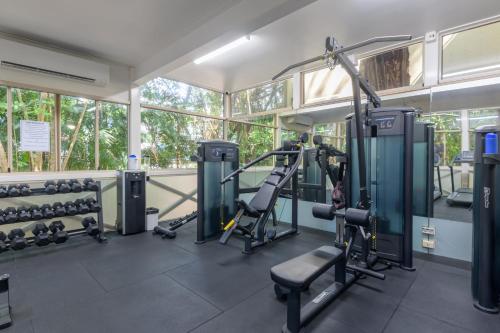 a gym with treadmills and machines in a building at Seascape Holidays at Ramadaresort in Port Douglas