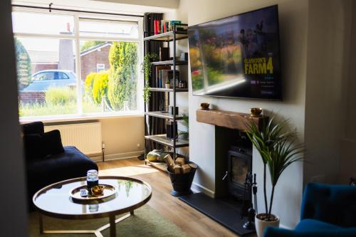 a living room with a table and a fireplace at Home from home in Gilesgate