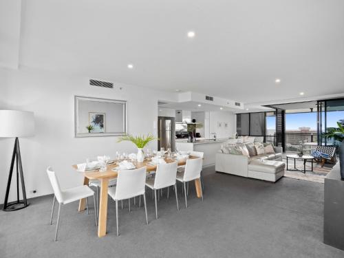 Un comedor y una sala de estar con mesa y sillas. en 2BR Unit Heart of Surfers Paradise - Spa, Pool, en Gold Coast