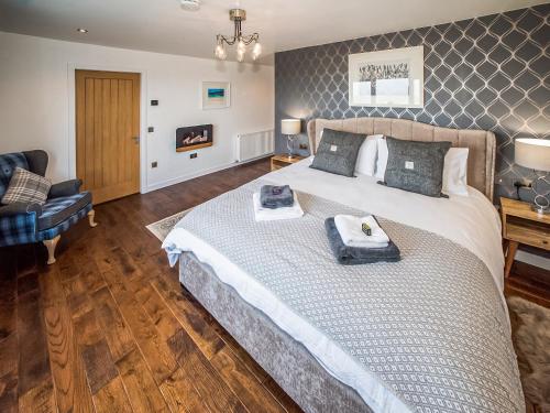 a bedroom with a large bed with towels on it at Two Seas Hebrides in Eoropie