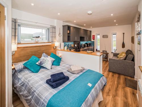 a bedroom with a large bed with blue pillows at Two Seas Hebrides in Eoropie