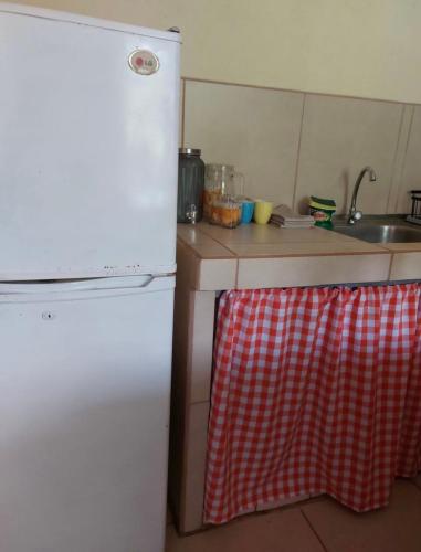 a kitchen with a white refrigerator and a sink at La Paz in Bahia