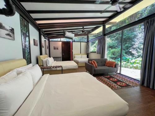 a bedroom with a large bed and a living room at Xscape Tambun in Ipoh