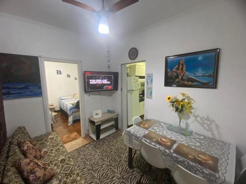 a living room with a couch and a table and a television at Apartamento frente a praia Santos in Santos
