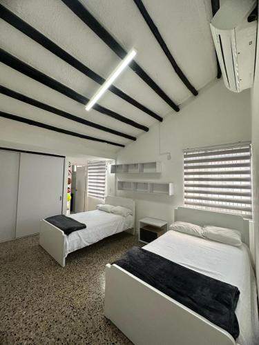 a bedroom with two beds and a black and white ceiling at Casa al lado de Multicentro in Ibagué
