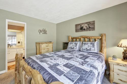 una camera da letto con un letto con una trapunta sopra di Boulder Bear Lakeside Condo- Big Bear Modern Retreat a Big Bear Lake