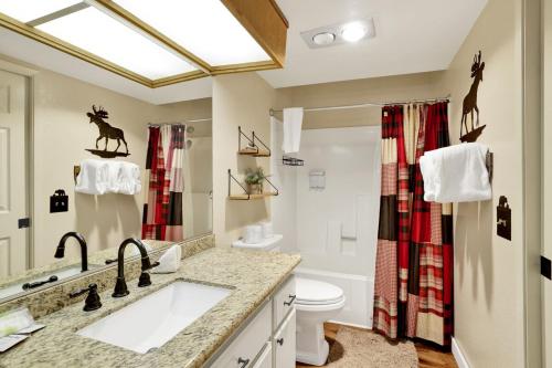 un bagno con lavandino e WC di Boulder Bear Lakeside Condo- Big Bear Modern Retreat a Big Bear Lake