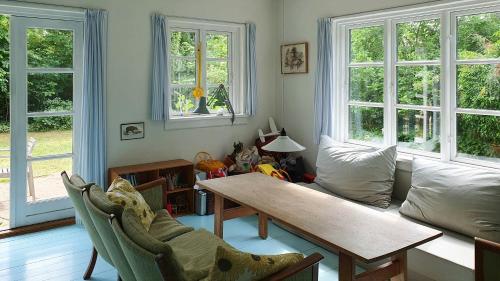 a living room with a table and a couch at Colour Joy In Thatched House Of The North Coast in Hundested