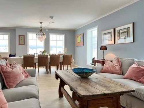 a living room with couches and a table and a dining room at Modern Beach House On Car-Free Vestre Sandøya in Kilen