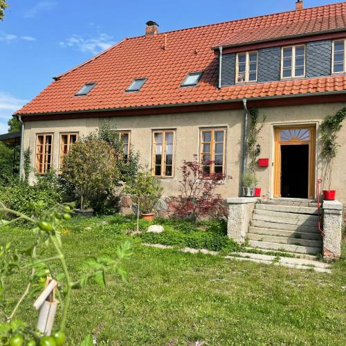 a house with a red roof and a yard at Stylish Holiday Apartment On Rügen Island in Rambin