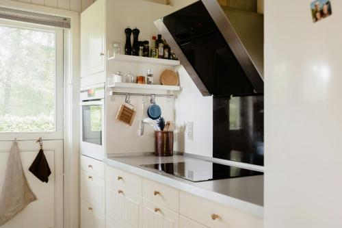 a kitchen with a stove top oven next to a window at Warm 70S Vibe Near Limfjord in Løgstør