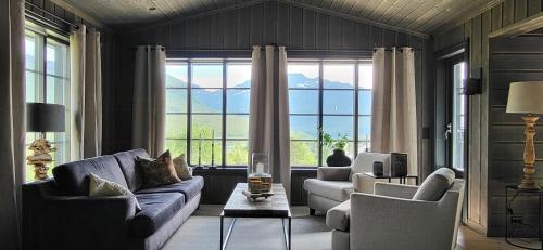a living room with two couches and a large window at Modern Cabin With Ski In-Out In Great Area in Brunstad