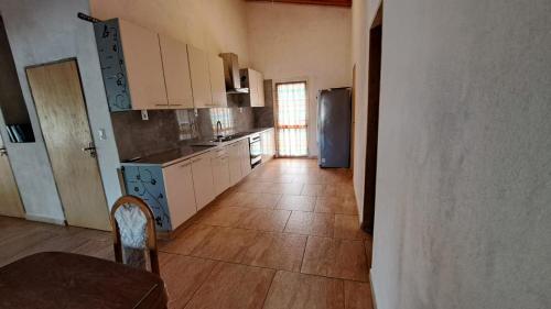 eine Küche mit weißen Schränken, einem Tisch und einem Kühlschrank in der Unterkunft Wall Apartamentos in Hohenau