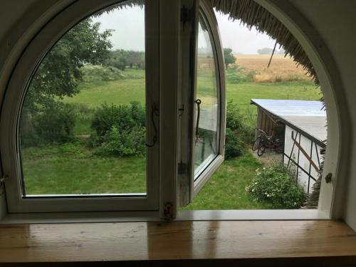 an arched window with a view of a field at Charming Country House Near Holten Beach in Nysted