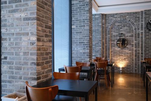 a restaurant with tables and chairs and a brick wall at 호텔 인썸니아 Hotel Insomnia 失眠酒店 in Daegu
