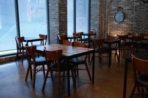 a row of tables and chairs in a room with windows at 호텔 인썸니아 Hotel Insomnia 失眠酒店 in Daegu