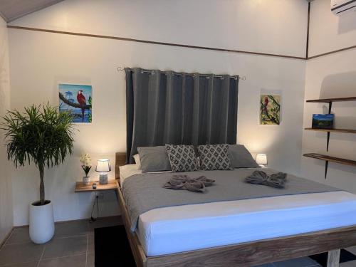 a bedroom with a large bed and a plant at El Rincon de la Suiza in Cahuita