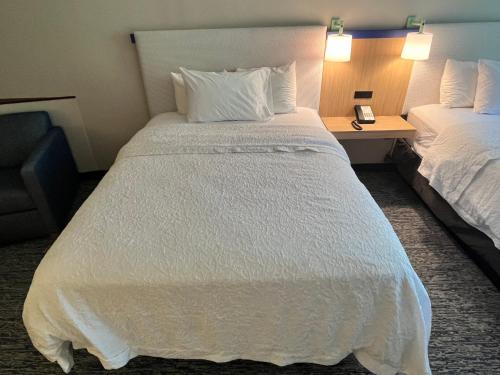 a large white bed in a hotel room at Tapa Hotel, Inn & Suites in Mahwah