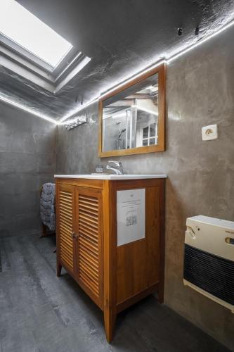 une salle de bain avec un lavabo et un miroir dans l'établissement ZENSAN Meublé Maison de Village Le Boulou 66160, au Boulou