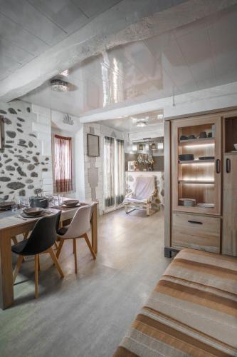 une cuisine et un salon avec une table et des chaises dans l'établissement ZENSAN Meublé Maison de Village Le Boulou 66160, au Boulou