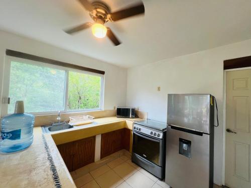 a kitchen with a stainless steel refrigerator and a sink at Vistas a las Montañas y al Mar I Condominio Las Calandrias I Alberca I Wi-Fi in Ixtapa