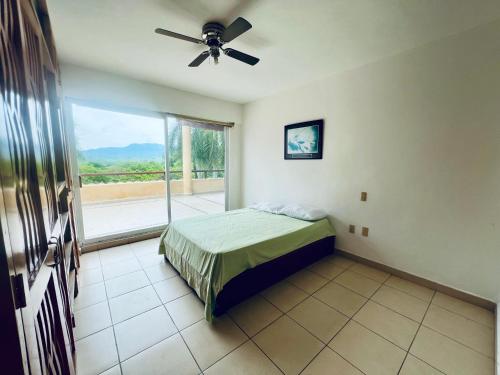 a bedroom with a bed and a ceiling fan at Vistas a las Montañas y al Mar I Condominio Las Calandrias I Alberca I Wi-Fi in Ixtapa