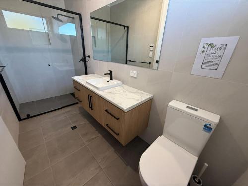 a bathroom with a toilet and a sink and a mirror at Koolywurtie in Pine Point