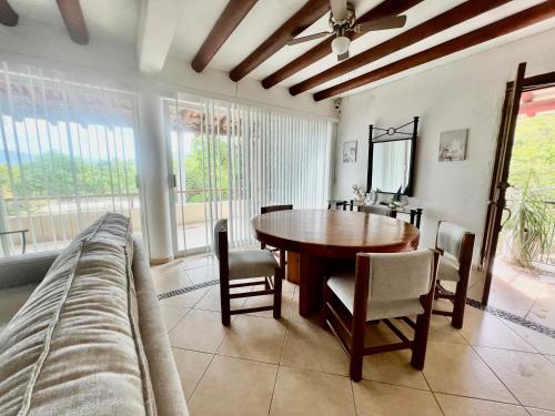 a dining room with a table and chairs and a couch at Vistas a las Montañas y al Mar I Condominio Las Calandrias I Alberca I Wi-Fi in Ixtapa