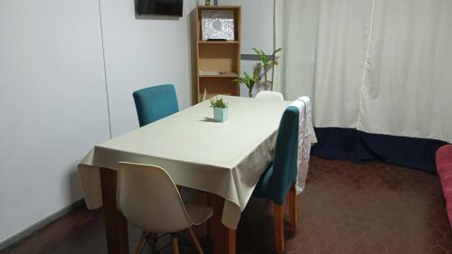 a table with chairs and a white table cloth on it at Dto dos dormitorios cerca del Español, Italiano, HPR, Club Provincial, Predio de la ex Rural in Rosario