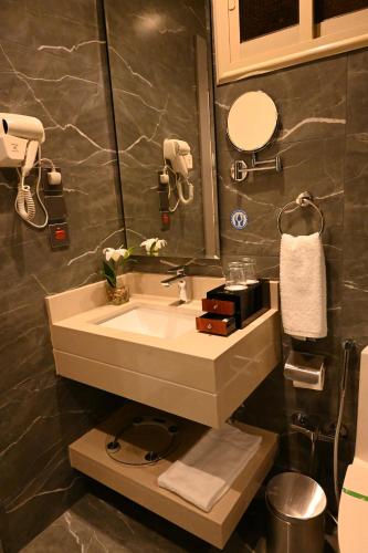 a bathroom with a sink and a mirror at فندق امان أبها - المعالي in Abha
