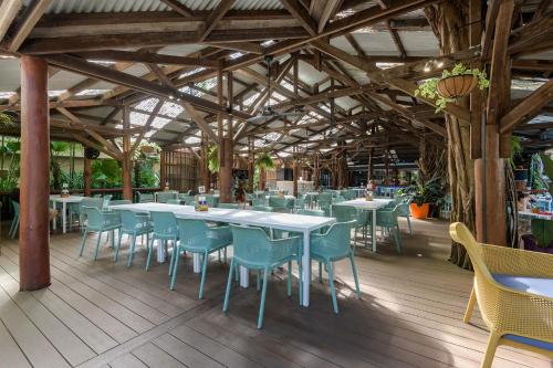 a dining room with tables and chairs in a building at Seascape Holidays at Ramadaresort in Port Douglas